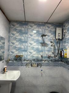a bathroom with a mural of clouds on the wall at Villa RISO in Boossa