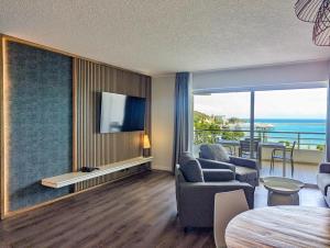 a living room with a couch and a tv and a table at Hilton Noumea La Promenade Residences in Noumea