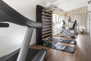 a fitness room with a treadmill and a gym at Hotel De Londres in Rimini