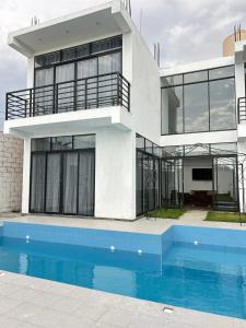 a house with a swimming pool in front of it at Casa Laguna in Trujillo