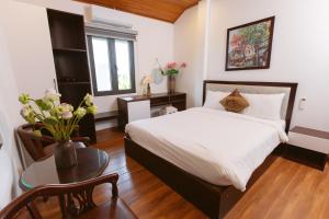 a bedroom with a bed and a table with a vase of flowers at Villa 750sqm with Pool and BBQ in Hue in Cồn Giả Viên +86 photos