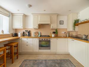 a kitchen with white cabinets and a stove top oven at 1 Bed in Wedmore CRIBB in Wedmore