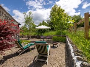 a patio with chairs and a table and an umbrella at 1 Bed in Wedmore CRIBB in Wedmore +7 photos