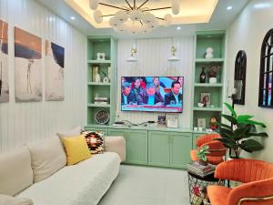 ein Wohnzimmer mit Couch und Flachbildfernseher in der Unterkunft 2BR Penthouse SMDC Wind Residences Tagaytay in Kaybagal