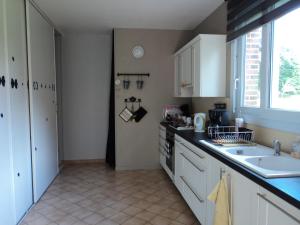 a kitchen with white cabinets and a sink and a window at La Demeure in Vassonville