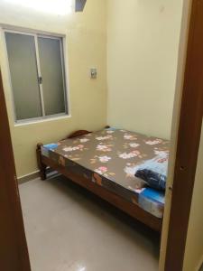 een klein bed in een kamer met een raam bij BPk ROOmS in Tiruvannamalai