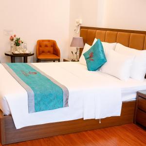 a bedroom with a large white bed with blue pillows at An Phú Hostel in Gia Lâm Pho