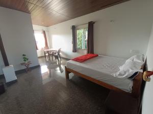 a bedroom with a bed and a table in it at Jishi Homestay in Madikeri