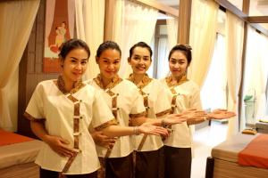 four women in white shirts and ties standing in a room at Eitanic Resort in Ban Don Tako