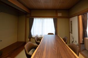 a conference room with a wooden table and chairs at Kamifurano House in Kami-furano