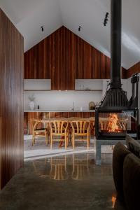 Il comprend une cuisine et une salle à manger avec une table et une cheminée. dans l'établissement The Grove Quindalup - Award Winning Luxury Accommodation, à Quindalup