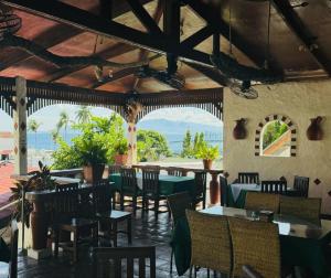 a restaurant with tables and chairs and a view of the ocean at Steps Garden Resort in Sabang