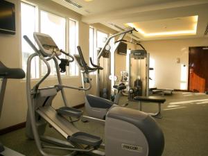 a gym with several tread machines in a room at Gulf Pearls Hotel in Doha