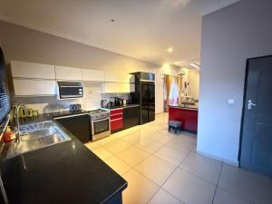 een keuken met zwart-witapparatuur in een kamer bij Spacious Modern 3-Bedroom Foxdale in Foxdale Estates