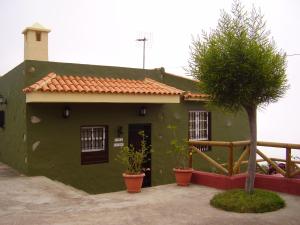 una casa verde con un árbol delante en La Orotava-casa Rural Los Nardos, en Montijos
