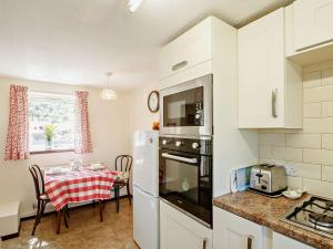 a kitchen with a table and a white refrigerator at 1 Bed in Conwy 92421 in Penmaen-mawr