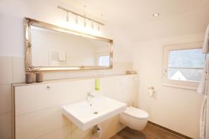 a white bathroom with a sink and a mirror at Hotel Vintage Am Bundesbank-Bunker in Cochem +120 photos