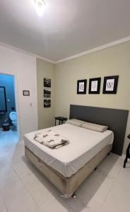 ein Schlafzimmer mit einem großen Bett mit vier Bildern an der Wand in der Unterkunft Casa De Ferias No Centro De Caldas Novas in Caldas Novas