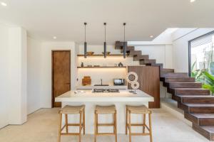 a kitchen with a white counter and a staircase at La Finca Bingin in Uluwatu