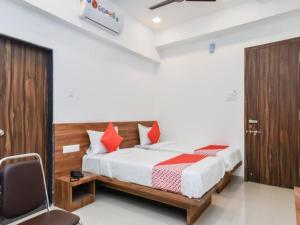 a bedroom with a bed and a chair in a room at Flagship The Address in Deolāli