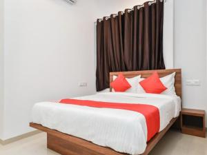 a bedroom with a large bed with red pillows at Flagship The Address in Deolāli