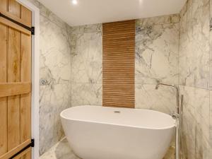 a white bath tub in a bathroom with marble walls at 2 Bed in Dalston 93820 in Dalston +10 photos