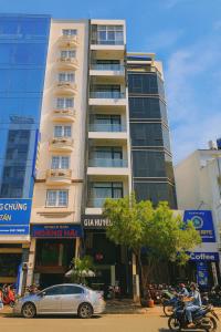 a tall building with a car parked in front of it at Gia Huyền Hotel in Ho Chi Minh City