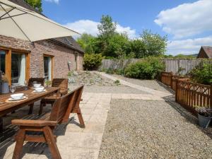 a garden with a wooden table and an umbrella at 5 Bed in Ludlow 95212 in Tugford
