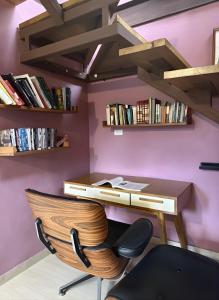 パナマシティにあるBeautiful Apartment with Balcony in the Heart of Panama Cityのデスク、椅子、本が備わる客室です。