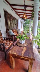 - une terrasse couverte avec une table en bois et un canapé dans l'établissement Beach House Madiha, à Matara