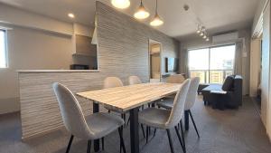 福岡市にあるLiving like hotel Hakata Premiumの木製のテーブルと椅子のあるダイニングルーム