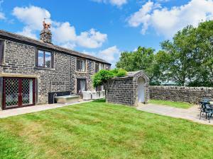 an exterior view of a brick house with a yard at 5 Bed in Halifax 96061 in Sowerby Bridge