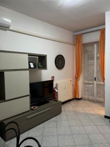uma sala de estar com televisão e um relógio na parede em Angy's Home em Corsico