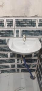 a white sink in a bathroom with tiles at श्री बांकेबिहारी सेवाधाम in Vrindāvan