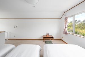 two beds in a white room with a window at Toya Serenity Stay in Lake Toya +172 photos