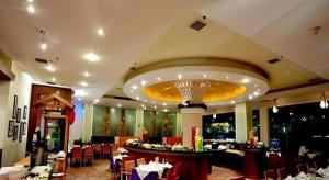 a dining room with tables and chairs in a restaurant at Dongguan Castfast Hotel in Qinglinjing