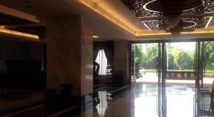 un vestíbulo con una gran puerta de cristal a una piscina en Nanning Qian Xi International Hotel, en Nanning