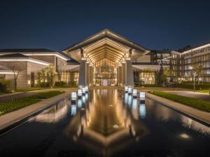 a building with a pool in front of it at night at Dongguan Yingbin Hotel in Dongguan