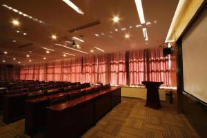 una gran sala de conferencias con filas de sillas y un podio en Xian Song Of Apple Hot Spring Hotel, en Xi'an