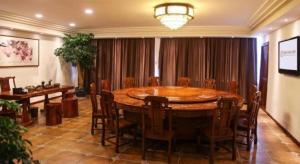 Un comedor con una gran mesa y sillas de madera. en Telecom Hotel Guilin, en Guilin