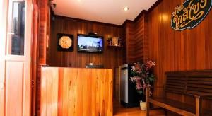 a room with wooden walls and a television and a bench at Ban Glai Kong in Chiang Khan +18 photos