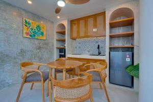 a kitchen with a table and chairs and a refrigerator at Sweet Escape 1BR Matahari LaLuxe A22 Sanur Villa in Sanur