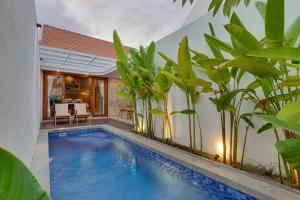 a swimming pool in front of a house with plants at Sweet Escape 1BR Matahari LaLuxe A22 Sanur Villa in Sanur