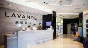a lobby of a hotel with people standing at a counter at Lavande Hotel Yantai Train Station Branch in Yantai