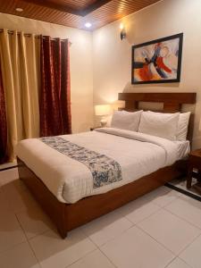 a bedroom with a large bed in a room at Nook House - Valley View Villa in Murree