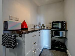 a small kitchen with a sink and a microwave at 1 Bed in Troutbeck nr Ullswater SZ254 in Troutbeck +5 photos
