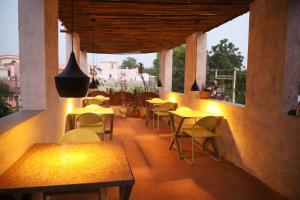 a restaurant with tables and chairs on a balcony at U-trn home stay in Bikaner