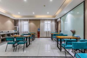 een eetkamer met tafels en blauwe stoelen bij Xana Lite Shenyang Beiling Park Liaoning Building Branch in Shenyang