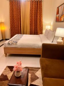 a bedroom with a bed and a couch and a table at Nook House - Valley View Villa in Murree