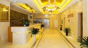 a hotel lobby with a reception counter and plants at Vienna 3 Best Hotel Jiangsu Suzhou Zhouzhuang Luzhi Ancient Town in Suzhou